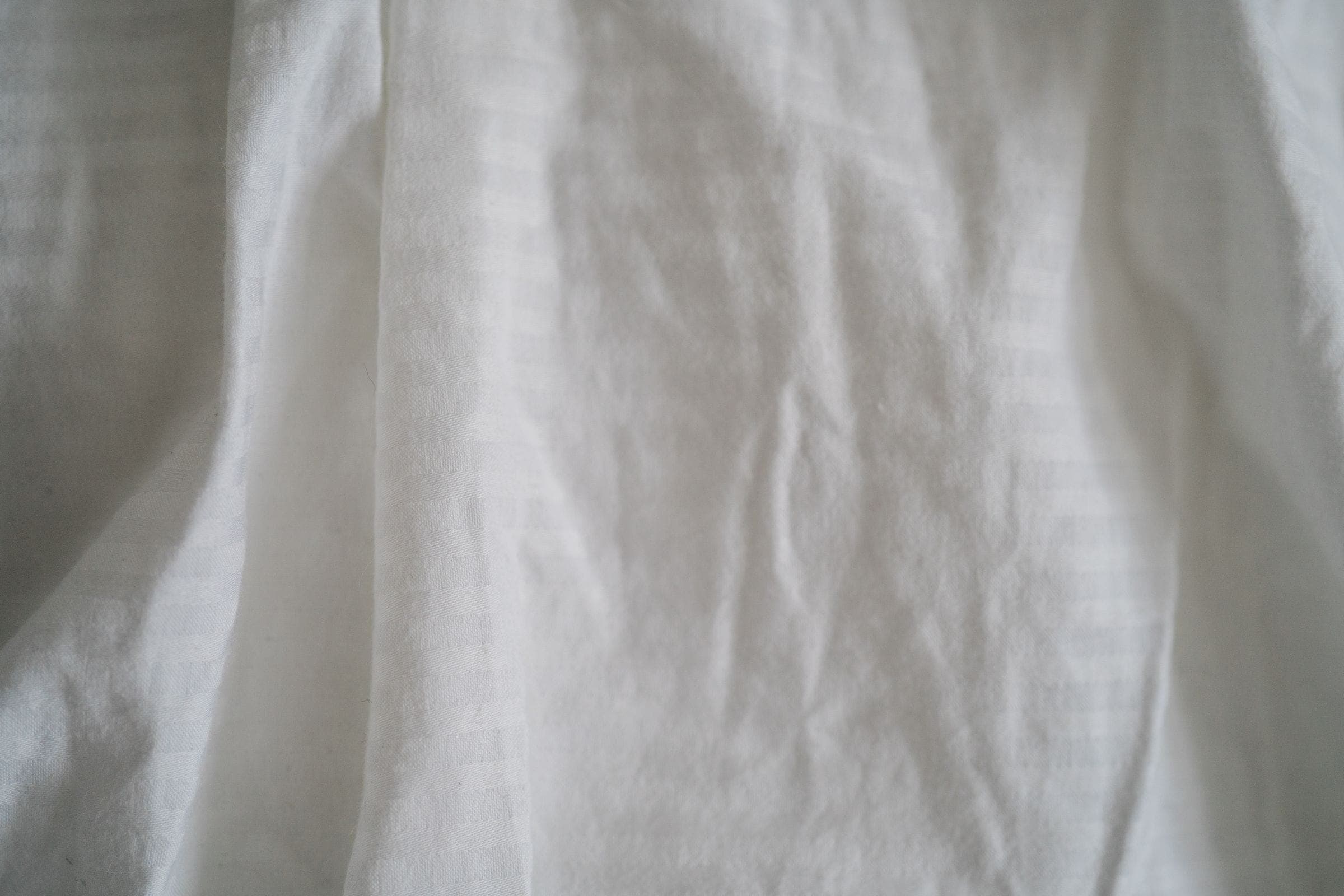 Softly wrinkled white cotton fabric in natural light